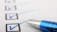 A blue inked pen checking boxes for a checklist